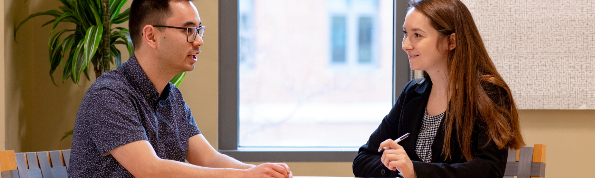 Man talking to women who is taking notes