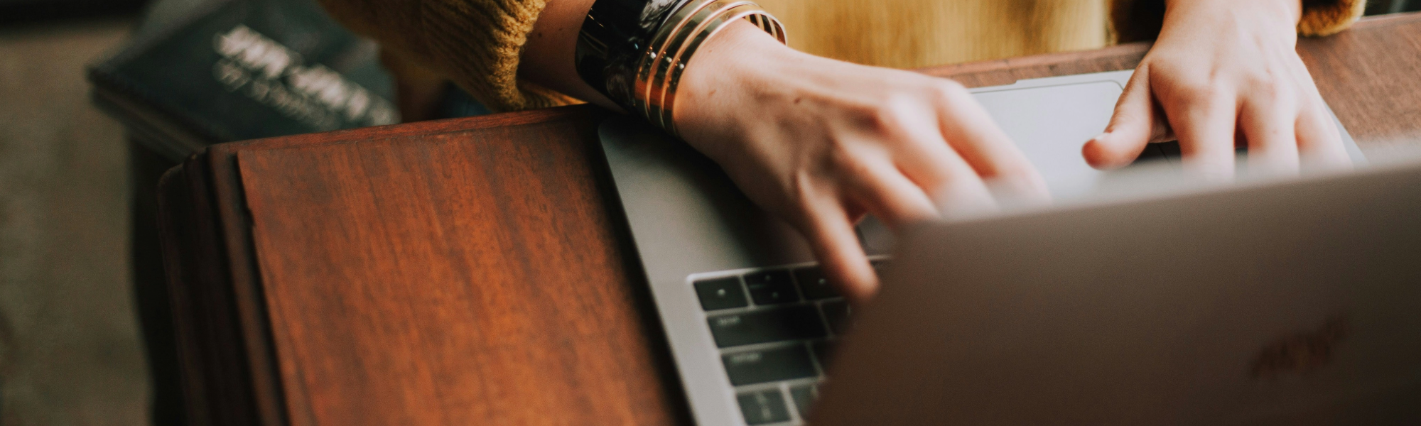 Hands typing on a laptop