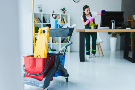 Woman with rubber gloves on cleaning a desk