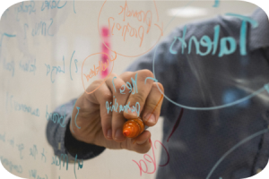 Man writing on a transparent whiteboard